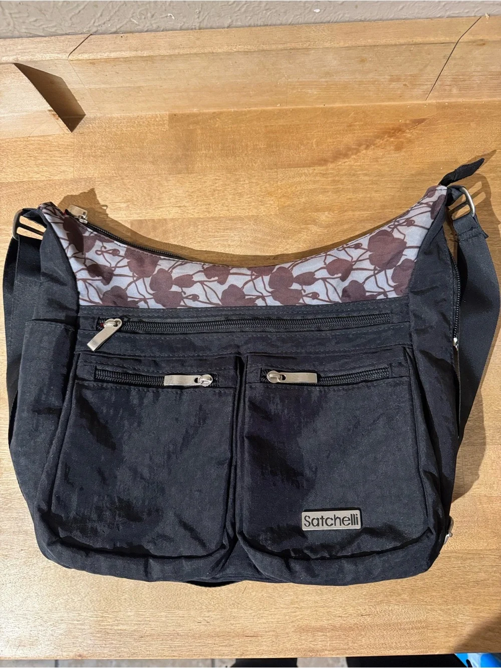 Satchelli Black Crossbody Bag with Floral Accent and Red Lining